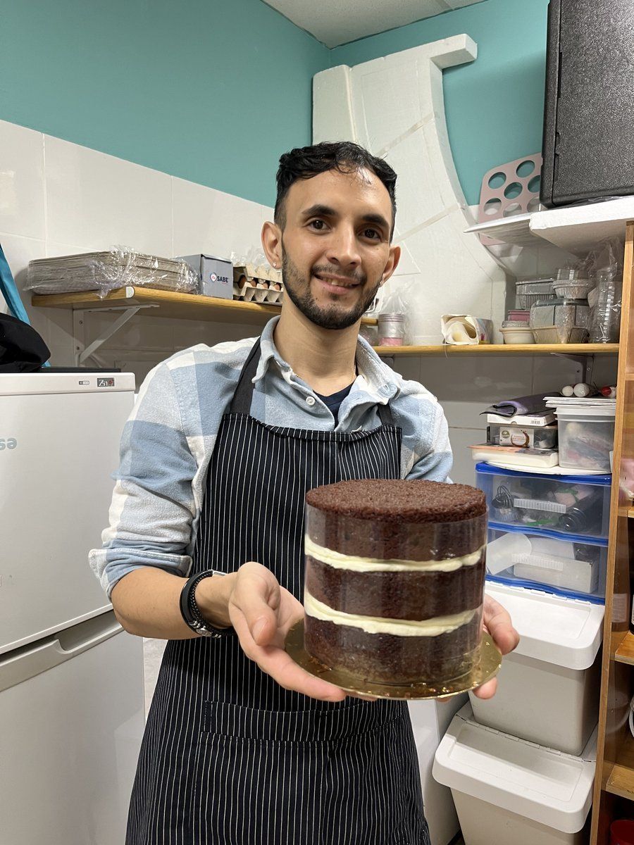Alumno mostrando tarta de capas montada con acetato